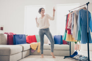 Women choosing what to wear dancing from clothes in her living room